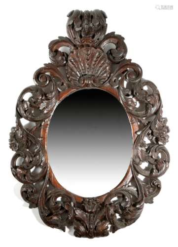 An 18th century stained fruitwood wall mirror, the later oval plate within a leaf, scroll and flower