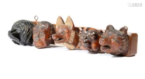 A late 19th century Black Forest hanging pipe rack, carved with the heads of five animals: a poodle,