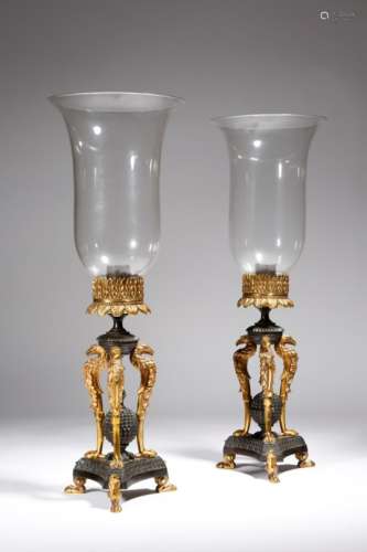 A pair of Regency gilt and patinated bronze storm lanterns, the bell shaped glass shades above a