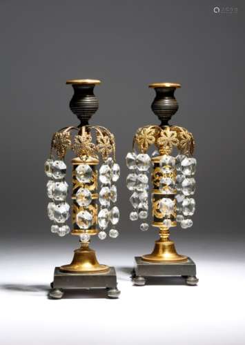 A pair of Regency gilt and patinated bronze lustre candlesticks, each with a ribbed nozzle with a