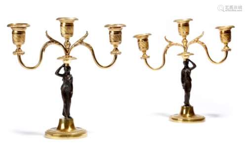 A pair of Regency gilt and patinated bronze figural candlesticks, each with a classical maiden