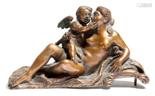 A bronze group of Venus and Cupid, reclining on a draped tasselled cushion, previously mounted,