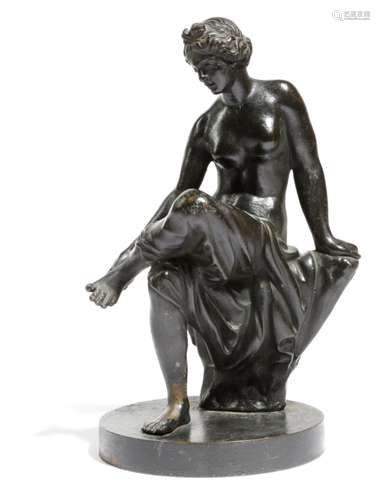 A 19th century Italian bronze figure of Venus, seated on a tree stump, at her bath, on a circular