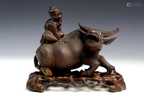 Chinese carved wood statue of a boy riding on an ox.