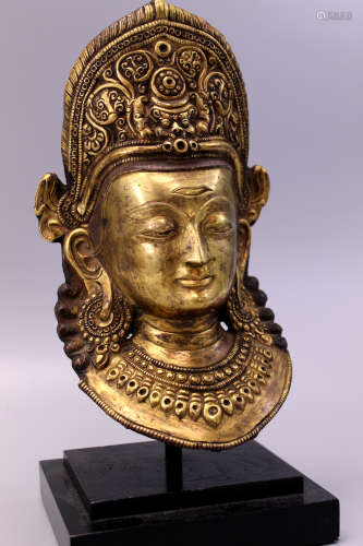 Tibetan gilt bronze Buddha mask on stand