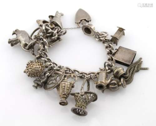 Silver charm bracelet with a selection of charms attached, total weight 79.7g