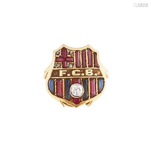 Insignia de solapa del FCB en oro con diamante y símiles de zafiro azul y rubí.