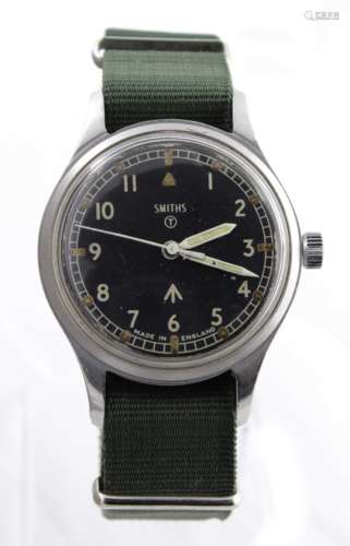 Military issue stainless steel gents wristwatch by Smiths. The black dial with Arabic numerals and