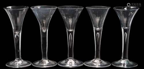 Five wine glasses: each trumpet shaped bowl tapering into a straight stem,