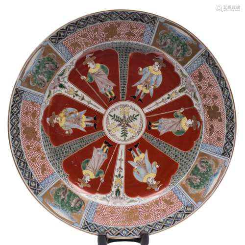 A Japanese Imari 'Dutch Merchant' charger: the cavetto painted with six iron-red ground lappet