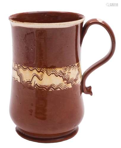 A Staffordshire glazed redware mug: of baluster form with strap handle and pinched terminal,