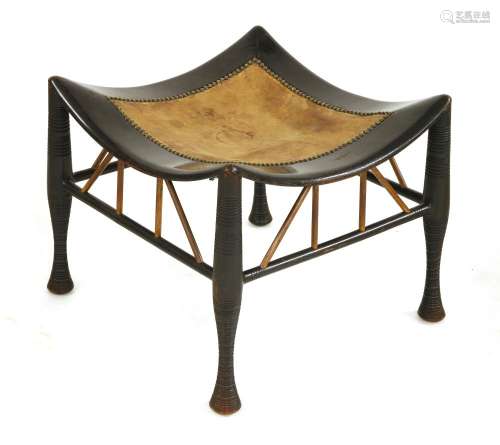 A Thebes ebonised stool,