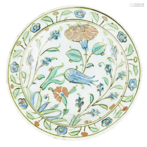 IZNIK UNDERGLAZE-PAINTED POTTERY DISH 17TH CENTURY with a flattened rim and shallow well,