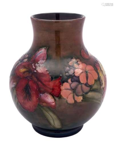 A Moorcroft pottery vase: tubelined in the Orchid and Spring Flowers pattern in red, yellow, green,