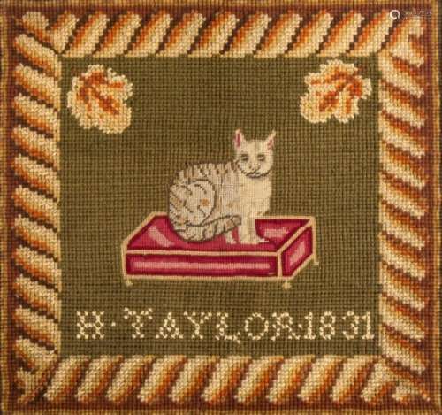A William IV woolwork picture depicting a cat seated on a cushion: worked in coloured wools of