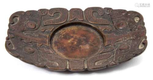 A Chinese bronze cup stand: of rounded rectangular form cast with taotie masks on a leiwen ground,