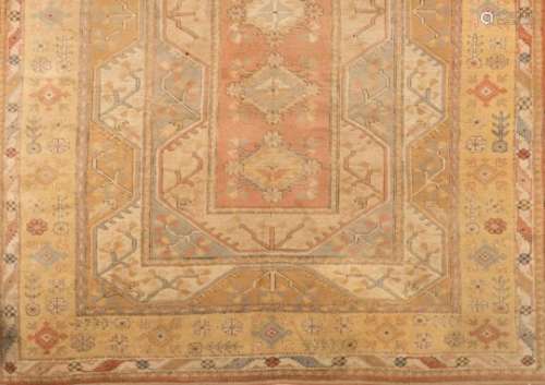 A Turkish carpet,: the shaded field in pastel colours of peach, blue and beige and yellow,