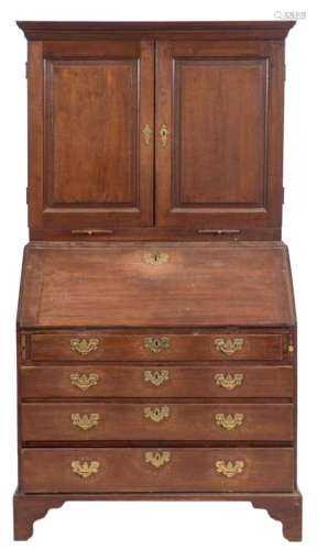 A mid 18th Century oak bureau cabinet:, the upper part with a moulded cornice,