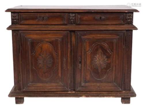 An 18th Century French Provincial carved walnut side cupboard:, with a rectangular moulded top,