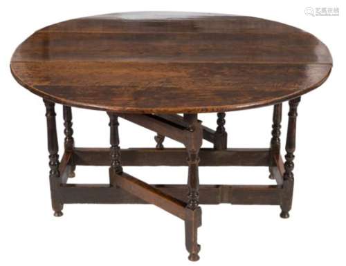 A George I oak gateleg table:, with an oval hinged top, on turned baluster legs,