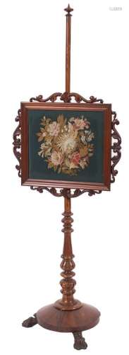 A Victorian carved mahogany pole screen:, with turned finial,