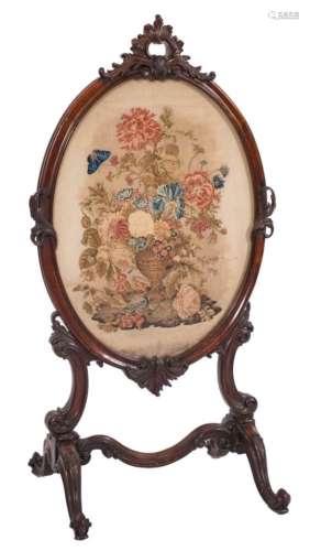 A Victorian carved rosewood oval firescreen:, with rocaille, C-scroll and acanthus leaf cresting,