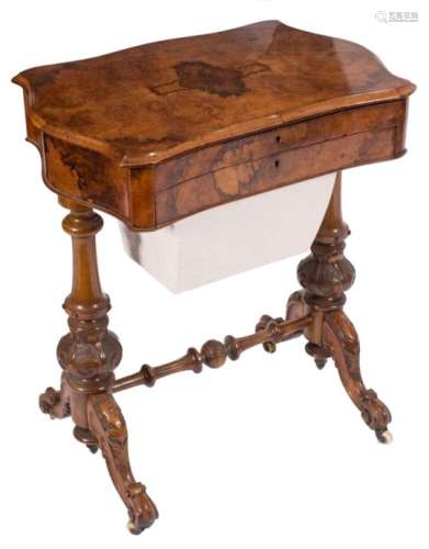 A Victorian burr walnut veneer combined writing and work table:, of serpentine shaped outline,