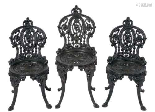 A suite of five Coalbrookdale type cast iron garden chairs:, three with lower backs,
