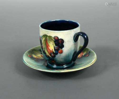 A Moorcroft Leaves and Berries coffee can and saucer,