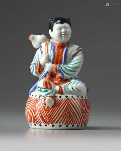 A Japanese figure of a boy on a drum