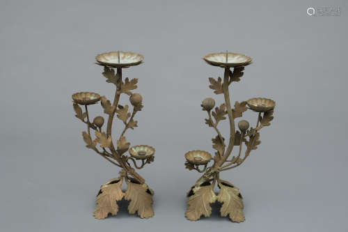 A set of two Japanese bronze candleholders with chrysanthemum leaves and flowers