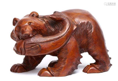 A large and heavy Japanese wood carving of a bear with a koi fish in its mouth.