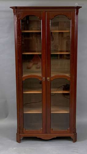 Vitrine en bois teinté en acajou ouvrant par deux portes, les montants pans coupés [...]