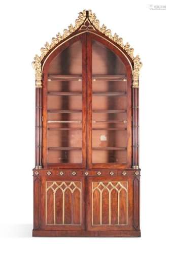 A REGENCY ROSEWOOD AND PARCEL GILT BOOKCASE, in th…