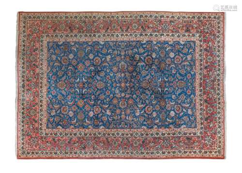 AN ISHFAHAN BLUE GROUND WOOL CARPET, woven with an…