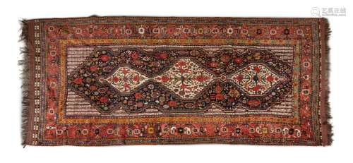 AN ANTIQUE PERSIAN RED GROUND RUG, of oblong shape…