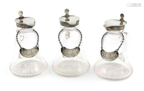 A set of three Edwardian silver mounted whisky tot…