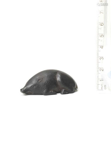 By Seiyodo Bunshojo (1764-1838), Iwami Province, early 19th century An ebony netsuke of a recumbent boar