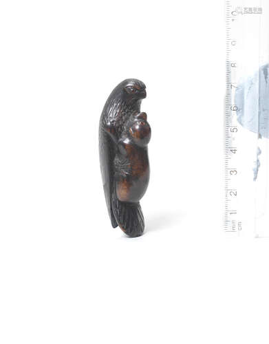 By Tsuramitsu (Kanman, 1793-1859), Iwami Province, first half of the 19th century A kurogaki (black persimmon) wood netsuke of an eagle clutching a monkey