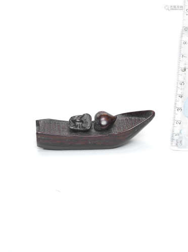 By Shoman, early 19th century A kurogaki (black persimmon) wood netsuke of a spider and chestnut in a boat