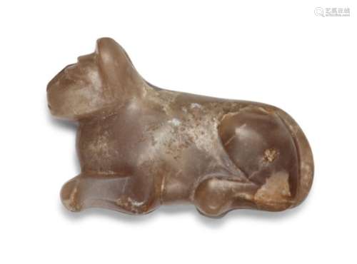 A carved agate cat weight, possibly Mesopotamian, shown crouching with ear pricked forward, the tail