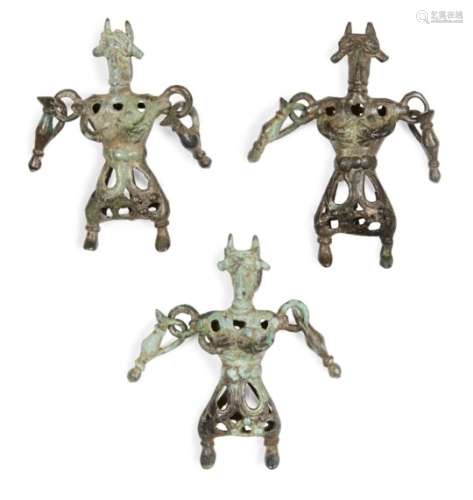 Three Amlash bronze openwork figures, 1st millennium B.C., standing their feet apart, horned and