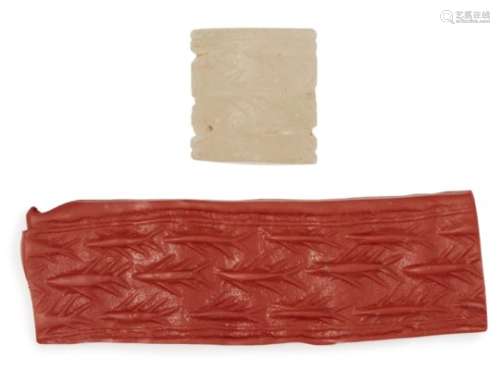 A large chalcedony cylinder seal, circa 3000 B.C., with shoal of swimming fish, 3cm. high