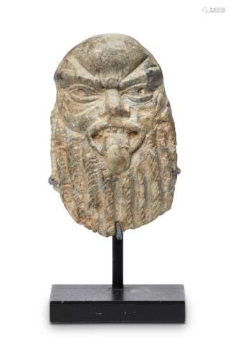 An Egyptian small stone carved head of Bes, possibly New Kingdom, 18th Dynasty, shown with