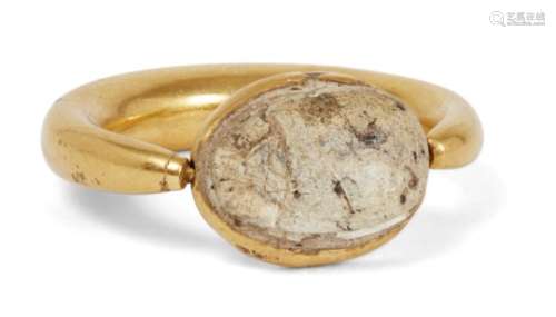 A gold ring with scarab setting, the thick rounded gold band tapering at the bezel, 2.9cm. diam.