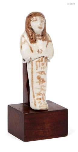 An Egyptian blue-glazed composition shabti, 26th Dynasty, modelled with arms crossed holding a hoe
