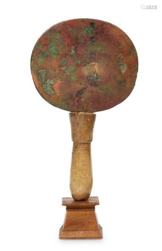 A bronze and calcite Egyptian Mirror, Middle Kingdom, 1938-1758 B.C., the disc shaped mirror set