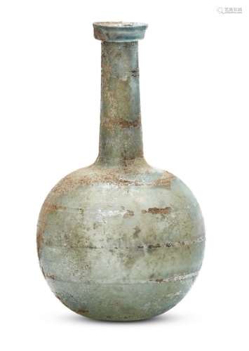 A Roman bluish-green glass bottle, 1st-2nd century A.D., with a folded collar rim on a long