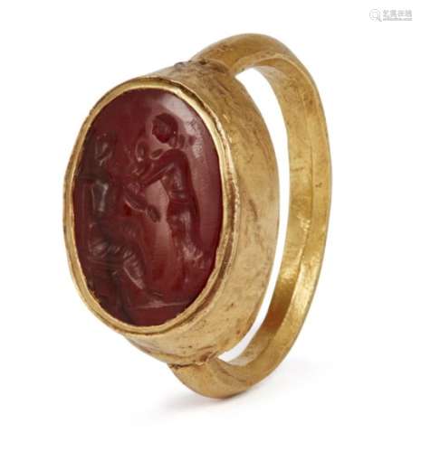 A gold Roman ring with carnelian intaglio of two figures and a child, 1st-2nd century A.D., with