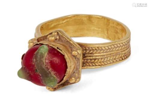 An ancient gold ring with red and green glass stone, ring size O approx., 3.5cm. high, weight 7.3gr.